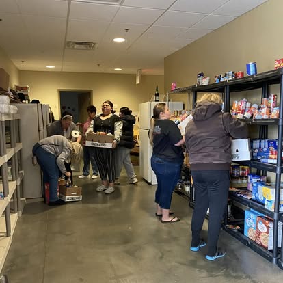 Volunteers organizing groceries on pantry shelves